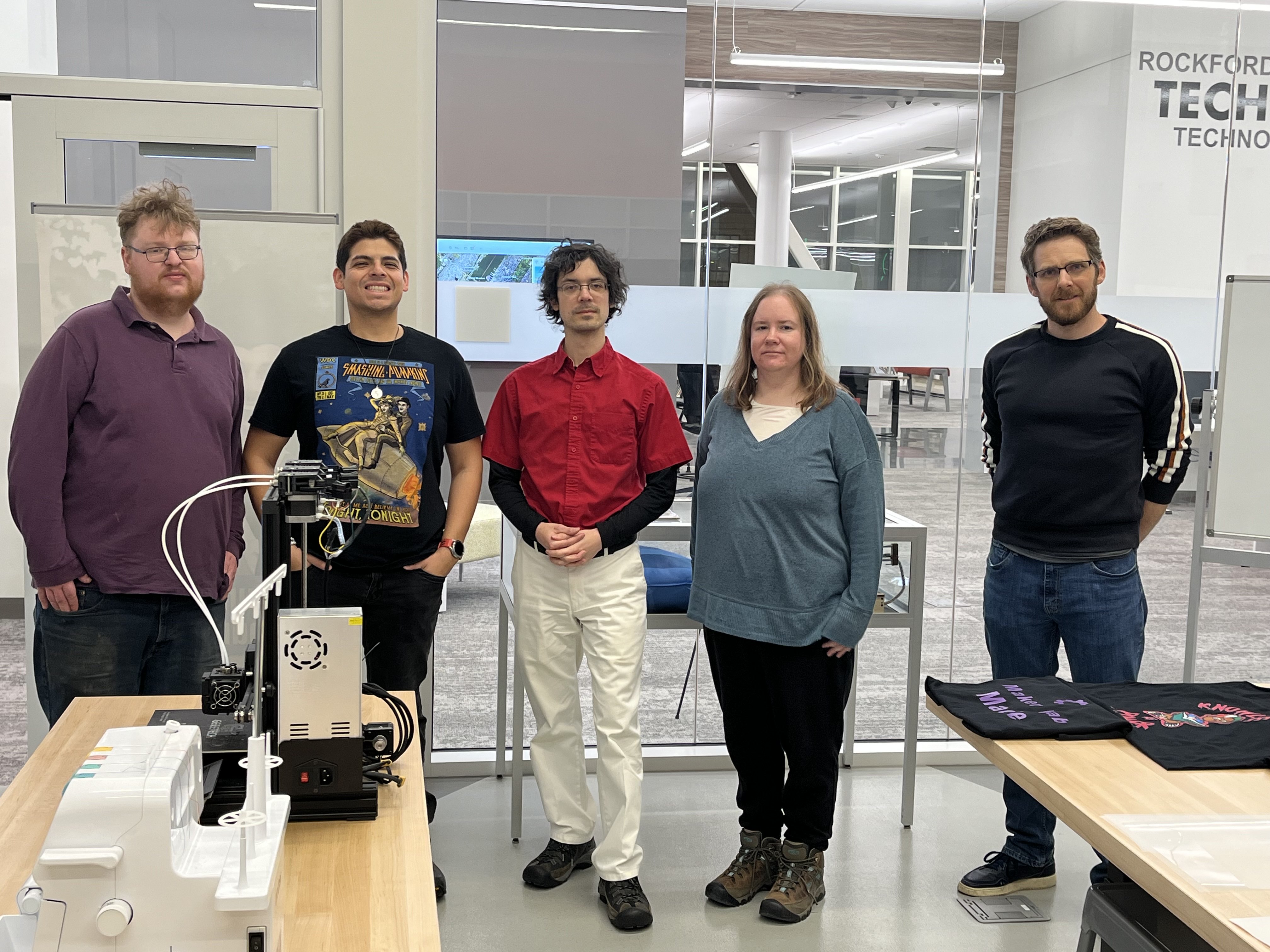 A photo of five members of the group in the Maker Lab